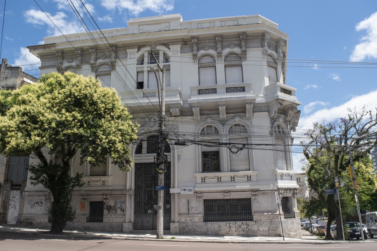 Fachada de prédio histórico, pintado de branco, que abriga a Escola da OSPA.