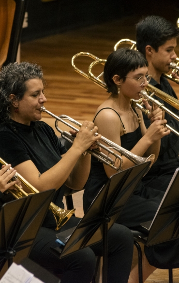 Orquestra de Sopros da Escola da OSPA durante o concerto "Cl&aacute;ssicos de Outono", na Sala Sinf&ocirc;nica da Casa da OSPA. Maestro Wilthon Matos rege os integrantes. Todos est&atilde;o vestidos de preto.