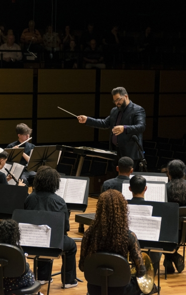 Orquestra de Sopros da Escola da OSPA durante o concerto "Cl&aacute;ssicos de Outono", na Sala Sinf&ocirc;nica da Casa da OSPA. Maestro Wilthon Matos rege os integrantes. Todos est&atilde;o vestidos de preto.
